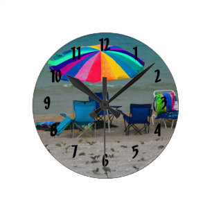 bunter Strandschirm sitzt Florida-Szene vor Runde Wanduhr