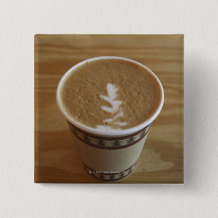 Cappuccino mit Baumentwurf im Schaum Button
