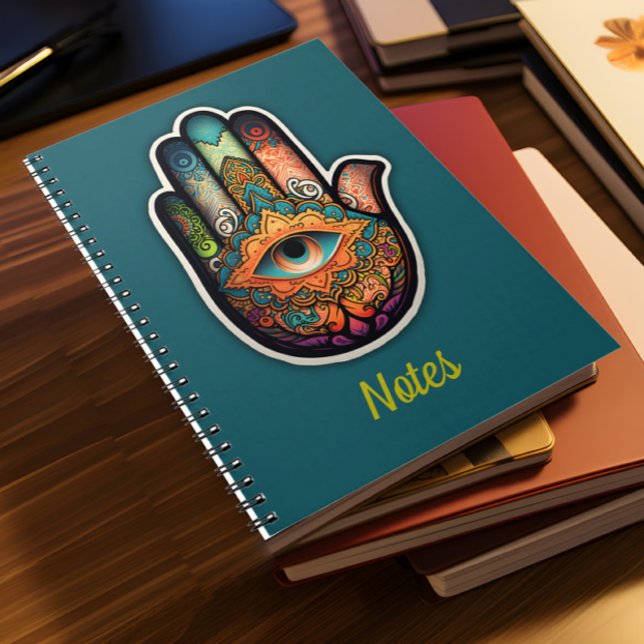 Carnet de spirale main Hamsa (A pile of notebooks lies on a desk)