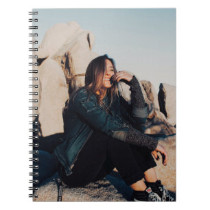 Carnet Femme assise et souriante portant un pantalon noir