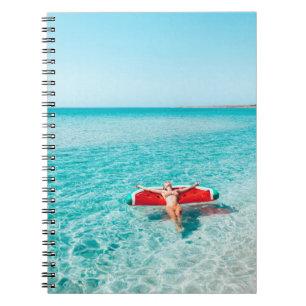 Carnet Femme sur lilo dans l'eau de mer. Fille se relaxer