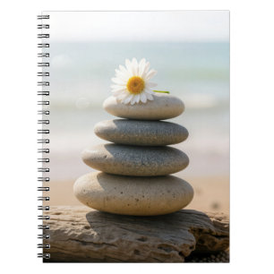 Carnet Pâquerette sur un cairn de plage en pierre avec bo