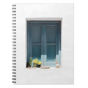 CARNET PORTE EN BOIS BLEU SUR MUR BLANC EN BÉTON