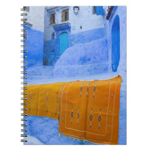 Carnet Tapis drapés sur un mur bleu