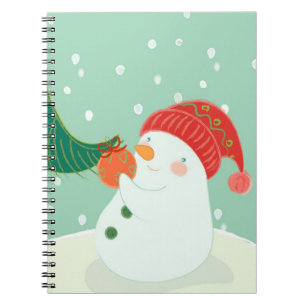 Carnet Un bonhomme de neige accrochant un ornement sur un