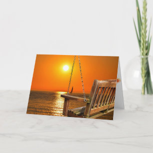 Carte balançoire en bois avec coucher de soleil sur la s