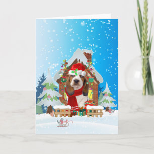 Carte Basset Hound dans la neige avec cadeaux de Noël
