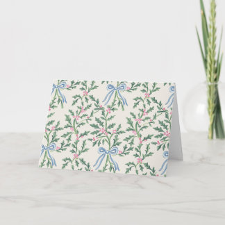 Carte de Noël à la vigne de houx avec ruban bleu