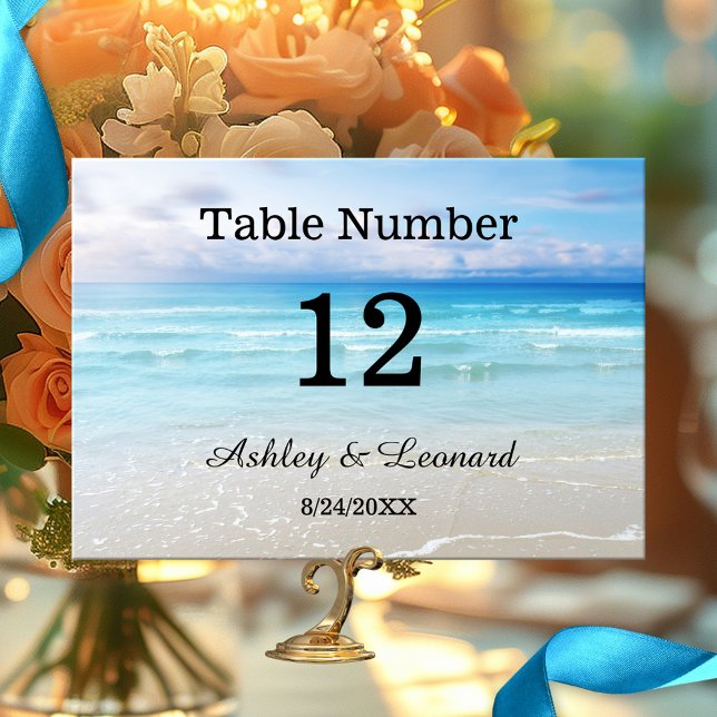 Carte de numéro de table de mariage artistique sur (Wedding table number card featuring a simple painting of a beach in vibrant colors)
