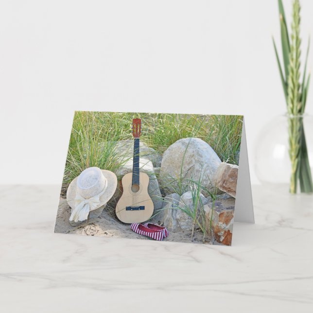 Carte guitare avec casquette et chaussures sur la plage (Devant)