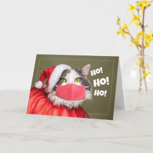 Carte Joyeux chat de Noël en tenue de Père Noël et masqu