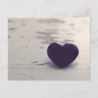 Coeur de pierre violet à l'âme sur une plage de sa