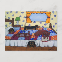 Carte postale de teckels lisant au lit