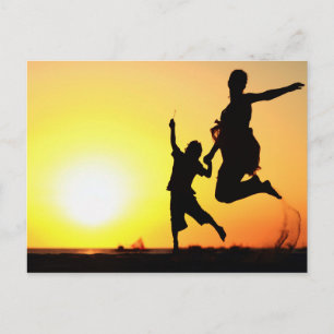 Carte Postale Silhouettes de mère et de fils sautant sur la plag