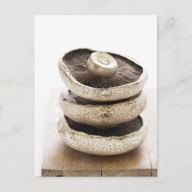 Carte Postale Trois champignons plats en pile sur une planche en (Devant)