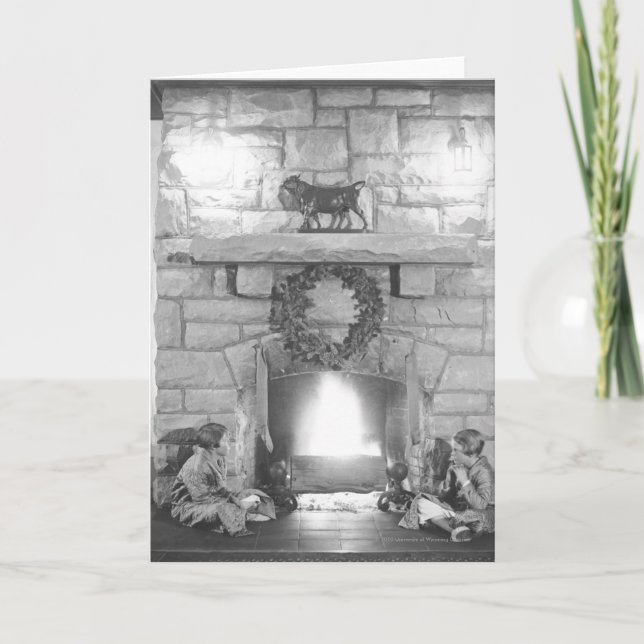 Cartes Pour Fêtes Annuelles Deux filles assises près d'une cheminée à Noël (Devant)