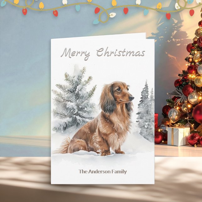 Cartes Pour Fêtes Annuelles Long Haired Dachshund Saucisse Chien Joyeux Noël (A Christmas card with illustration of a long-haired dachshund "sausage dog" with pine trees in snow)