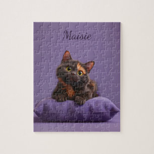 Cartoon Tortoiseshell Kitten auf Lila Polster