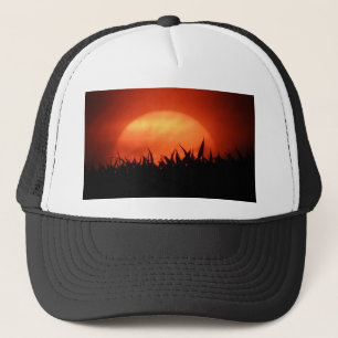 Casquette Soleil rouge derrière l'herbe noire