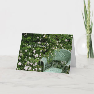 Chaise en osier parmi les fleurs Carte de voeux An