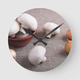 Champignon mushrooms and onions on the table runde wanduhr
