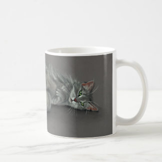 Chat gris roulant au-dessus de la tasse de café