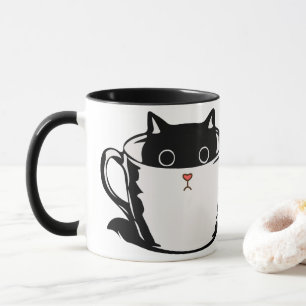 Chaton noir avec nez rouge caché dans une tasse