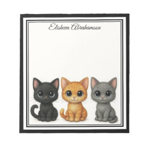Chats drôles qui regardent par-dessus un bloc-note