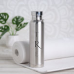 Chic Monogram auf Silber Trinkflasche<br><div class="desc">Das schicke, schwarze, vertikale Monogramm auf Silber weist eine größere dekorative Initiale in der Mitte auf. Ersetzen Sie die 3 Initialen durch Ihre eigene in der Sidebar. Weitere Farben und Stile der Wasserflasche sind in der Sidebar erhältlich. Copyright © Claire E. Skinner. Alle Rechte vorbehalten.</div>