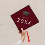 Chic Red Hat Class Year Graduation Cap Topper<br><div class="desc">Dieser schicke,  rote Hutklassenkopftopper ist perfekt für einen modernen Abschluss. Das schlichte Design zeichnet sich durch eine klassische dunkelbordeauxrote und weiße Typografie mit einem schwarz-goldfarbenen Abschluss-Hut aus. Personalisieren Sie Ihre Graduierungspauschale mit dem Jahr.</div>