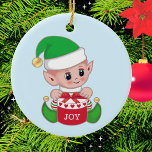 Christmas Green Elf Keramik Ornament<br><div class="desc">Niedliche Weihnachtself mit Geschenkboxen auf hellblauen Ornament. Man glaubt, dass die Elfen kleine Engel der Erde sind. Joy Text kann mit einem kurzen Text oder Monogramm personalisiert werden.</div>
