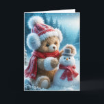 Christmas Teddy Bear Gebäude a Snowman Feiertagskarte<br><div class="desc">Ein brauner Teddybär in einem Hut,  Ohrmuffs und Rotschal baut einen kleinen Schneemann in einem Winterwald</div>