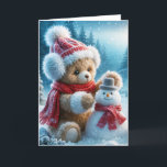 Christmas Teddy Bear Gebäude a Snowman Feiertagskarte<br><div class="desc">Ein brauner Teddybär in einem Hut,  Ohrmuffs und Rotschal baut einen kleinen Schneemann in einem Winterwald</div>
