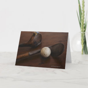 Close up of antique golf clubs and golf ball karte