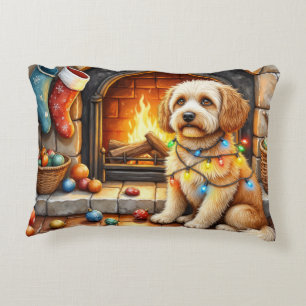 Cockapoo sitzt neben dem Kamin mit Weihnachtsbeleu Dekokissen