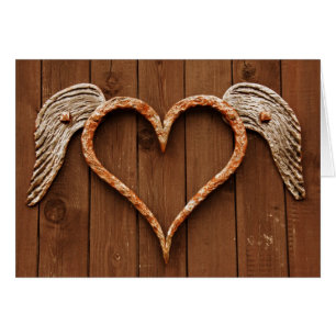 Coeur avec ailes contre les planches en bois rusti