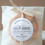 Colorado Springs Skyline | Begrüßungsnachricht Runder Aufkleber<br><div class="desc">Erweitern Sie Ihre Hochzeitspakete oder Event-Gastgeschenke mit einem individuellen Set von Begrüßungsaufklebern! Diese eleganten und minimalistischen Aufkleber sind auf eine Hochzeit in der schönen Stadt Colorado Springs, Colorado zugeschnitten. Sie verfügen über eine moderne Skyline aus Deko, die den Namen der Stadt trägt und darunter integriert ist. Alle Elemente des Designs,...</div>
