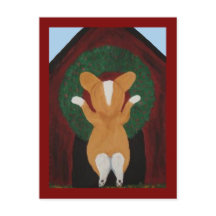 Corgi hängt Weihnachtskranz an das Hundehaus