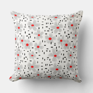 Coussin gris avec des fleurs rouges sur fond blanc rétro