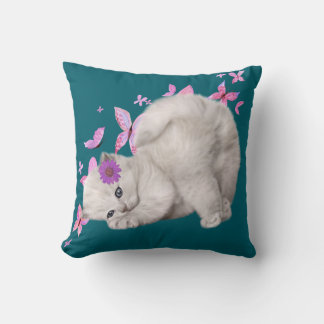 Coussin Kitten blanc bouffant entouré de fleurs roses et