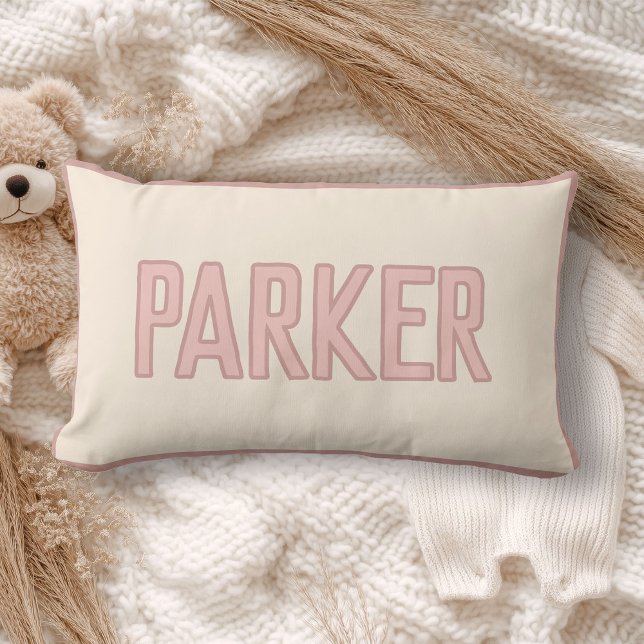 Coussin Rectangle Joli nom d'enfant personnalisé avec fausse garnitu (A cream pillow with "WILDER" in light pink lettering lies on a cozy, soft-knit blanket)
