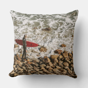 Coussin Surfeur marchant sur une plage rocheuse, vagues oc