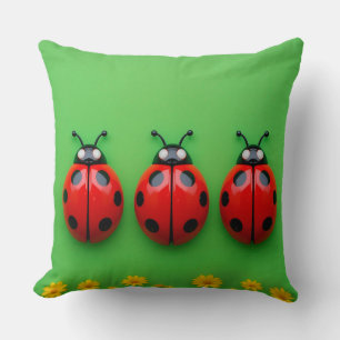 Coussin Trois coccinelles colorées sur fond vert