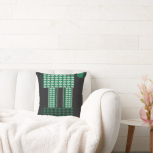 Coussin un motif vert et noir avec un arbre au milieu
