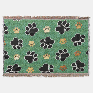Couverture Tan et empreinte de patte noir sur herbe verte