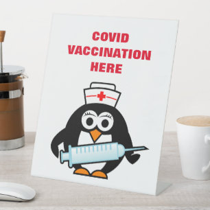 Covix-Impftheke mit Cartoon Sockelschild