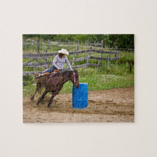 Cowgirl auf dem Pferd, das im Fass-Rennen in