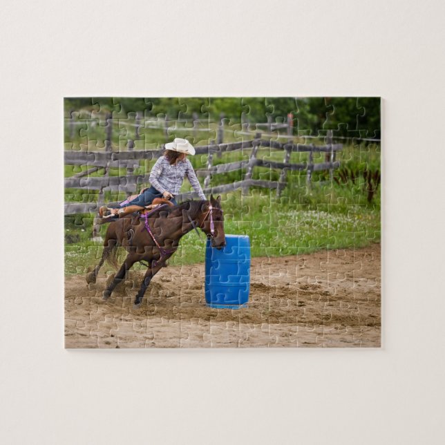 Cowgirl auf dem Pferd, das im Fass-Rennen in (Horizontal)
