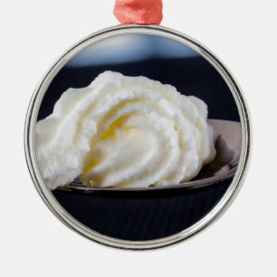Creme auf einem Löffelmakro-Konzept Silbernes Ornament