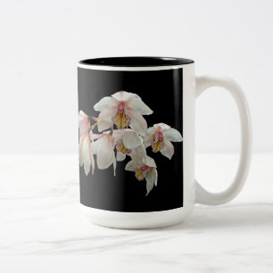 Creme und rosa Orchideen auf schwarz Zweifarbige Tasse